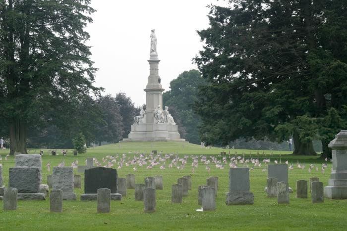 A cemetery with a large statue in the background