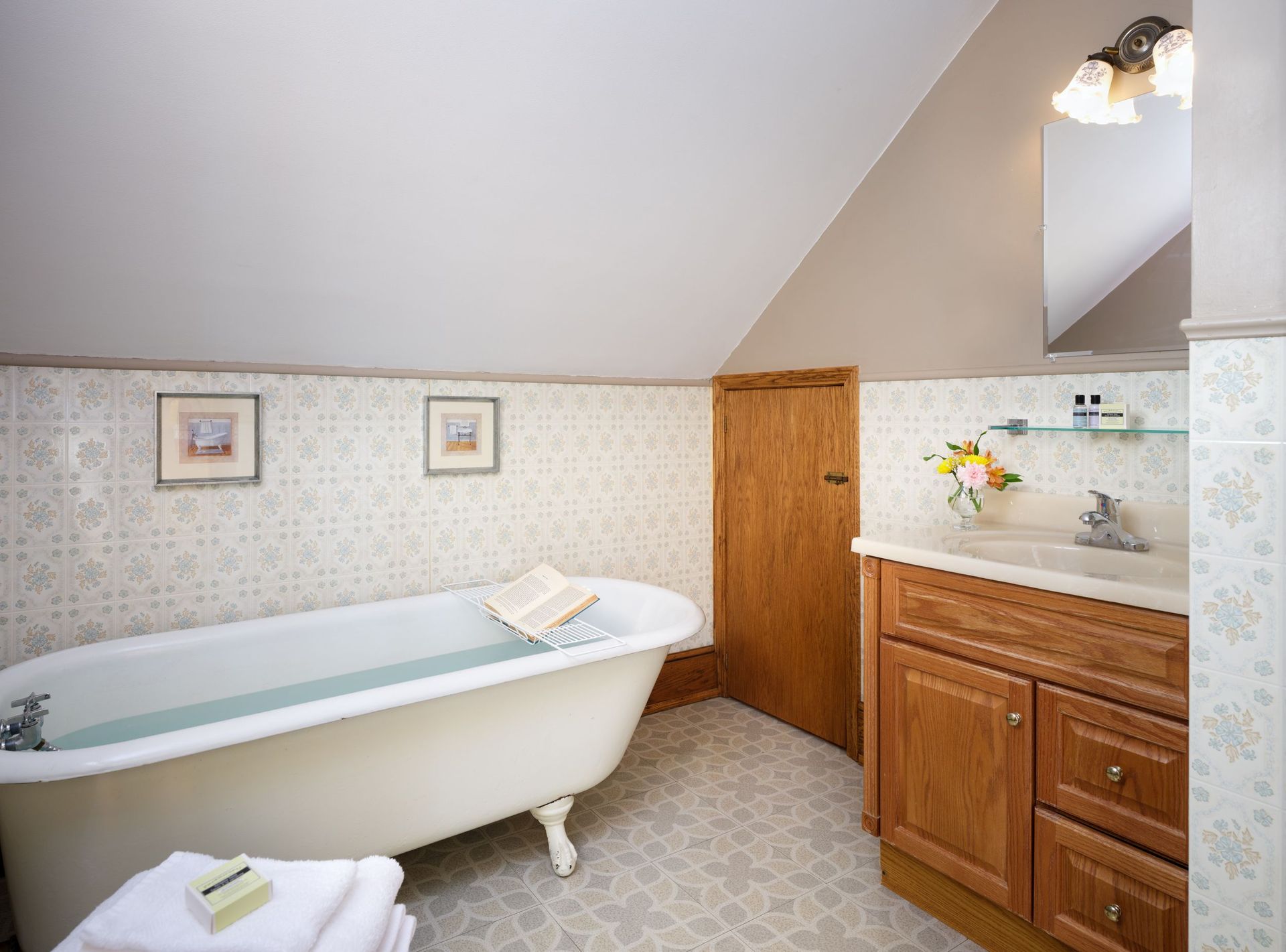 A bathroom with a bathtub , sink , and mirror.