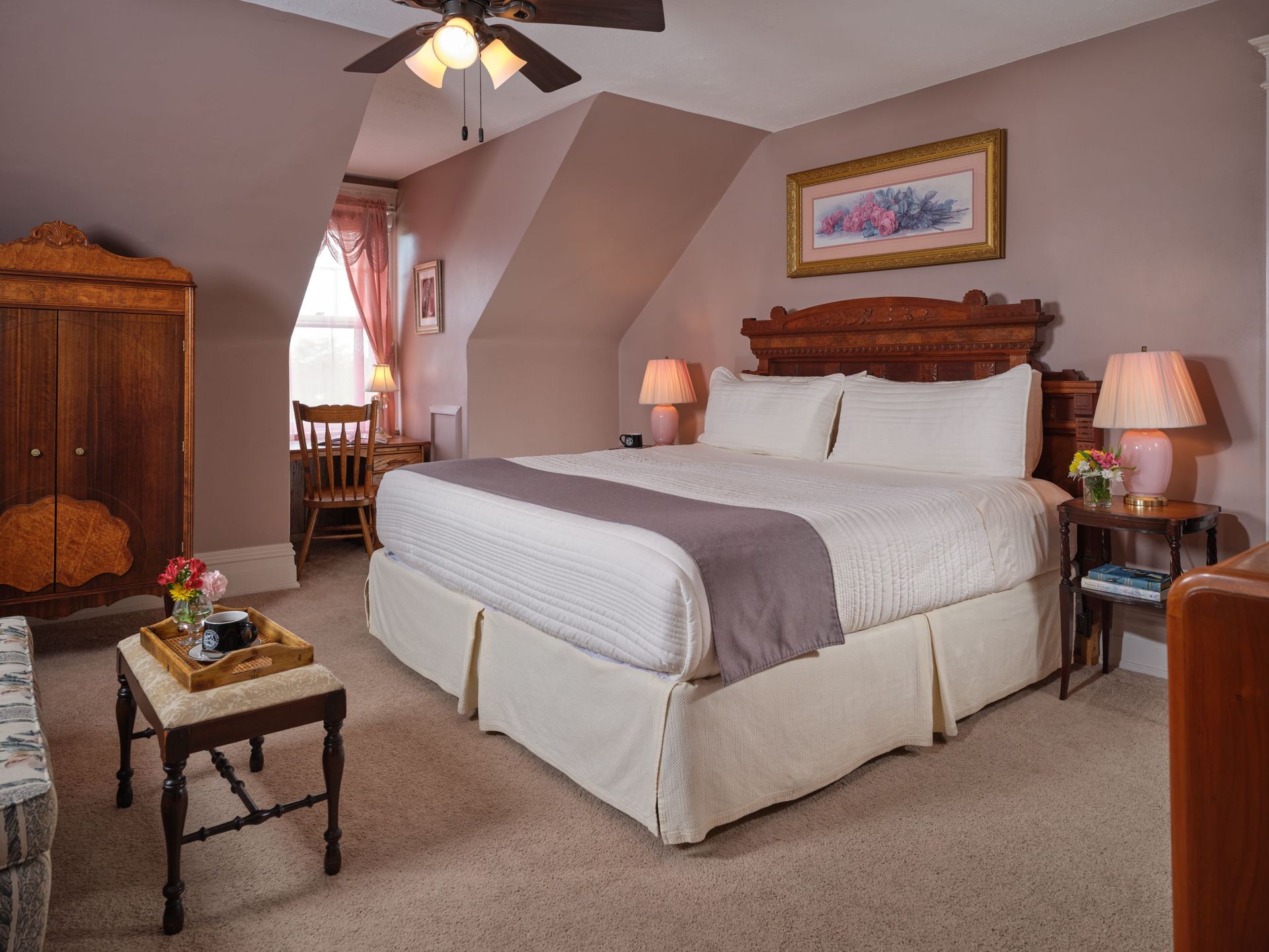 A bedroom with a king size bed and a ceiling fan