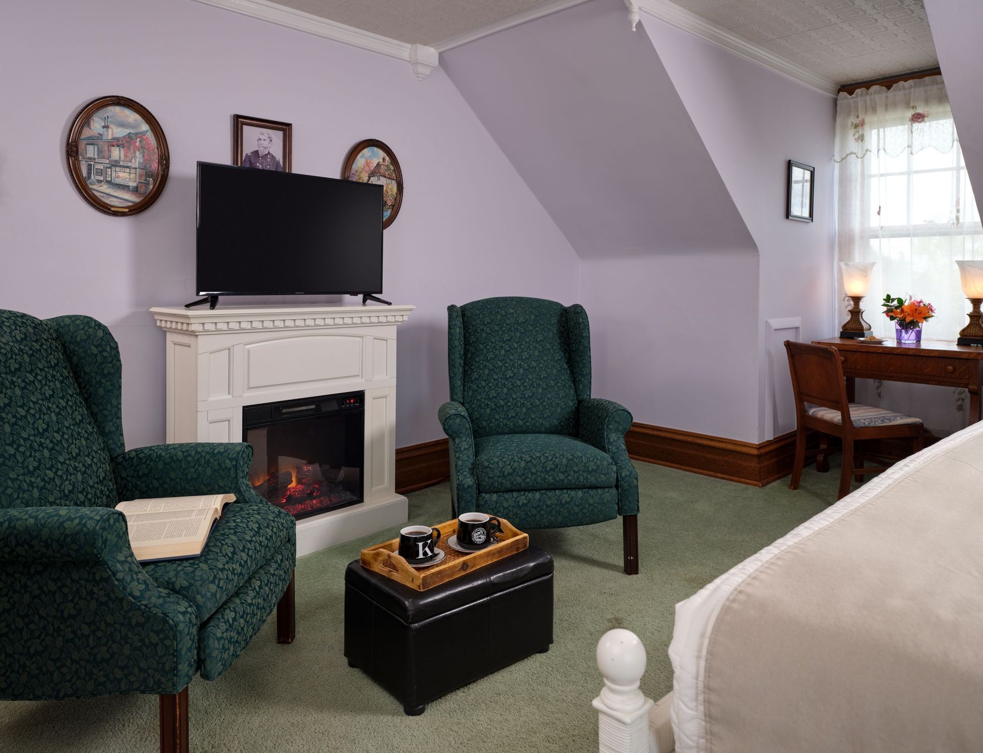 A living room with two chairs , a fireplace and a flat screen tv.