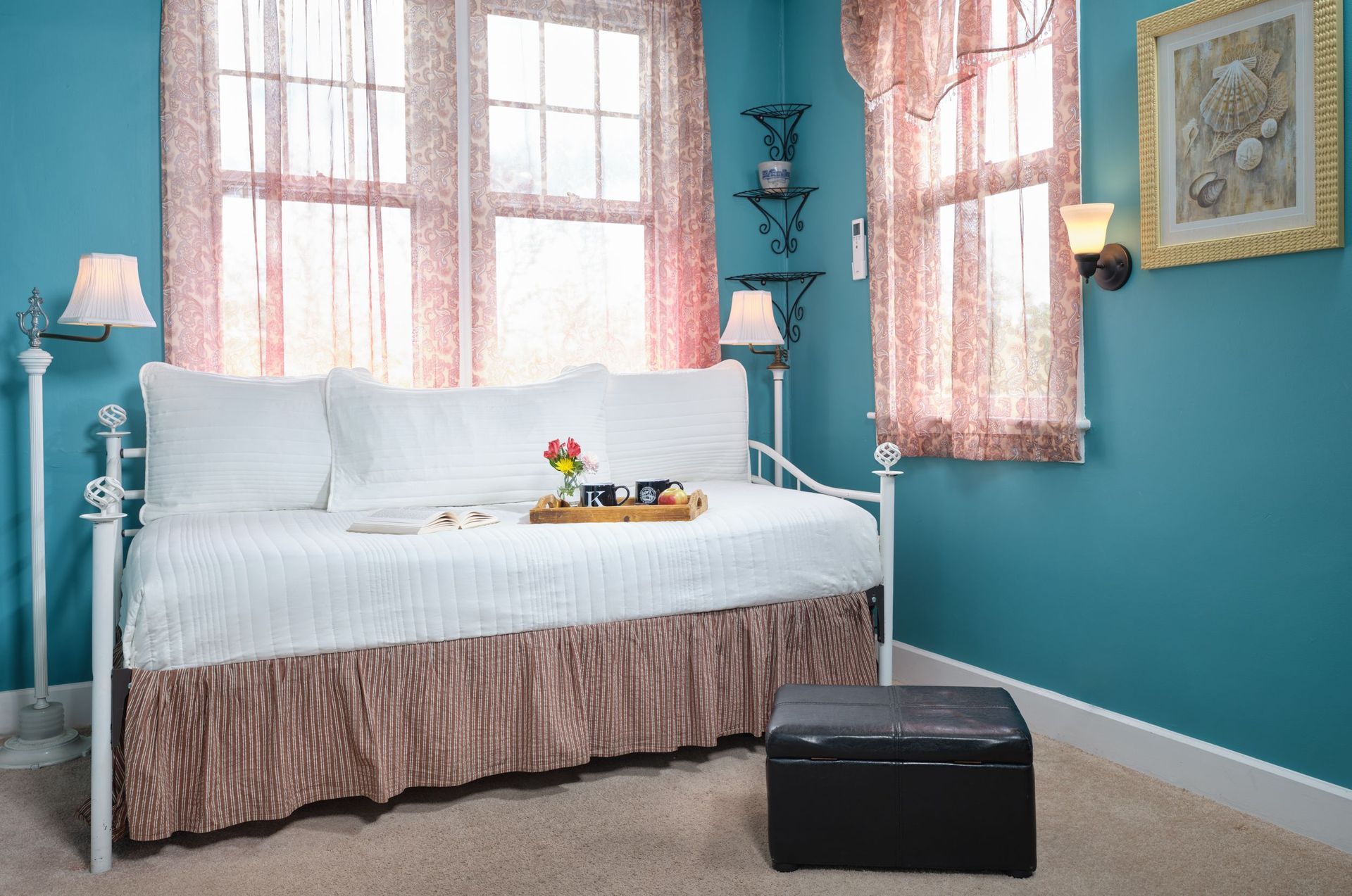 A day bed with a tray on it in a bedroom with blue walls