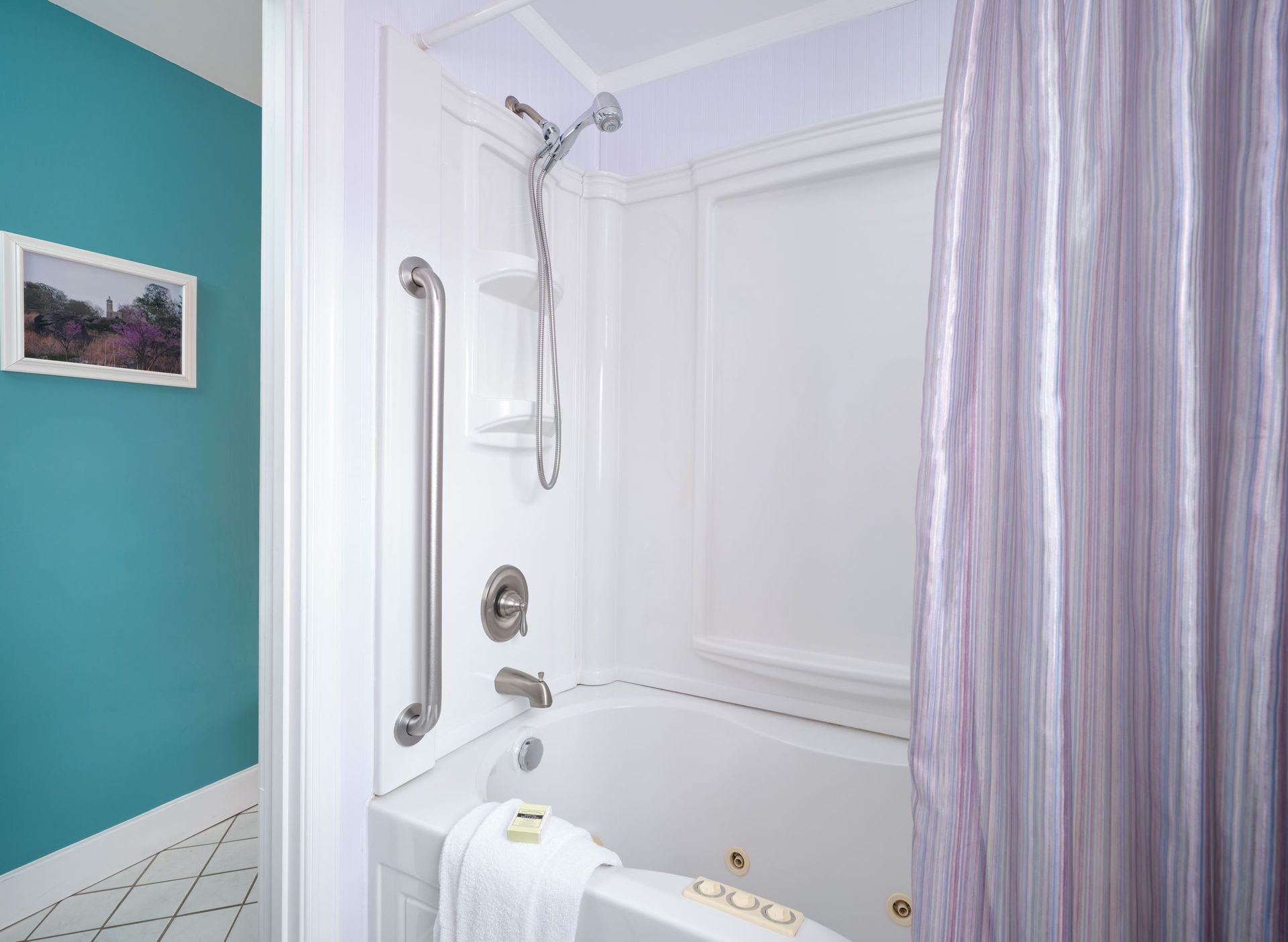 A bathroom with a jacuzzi tub and a purple shower curtain.