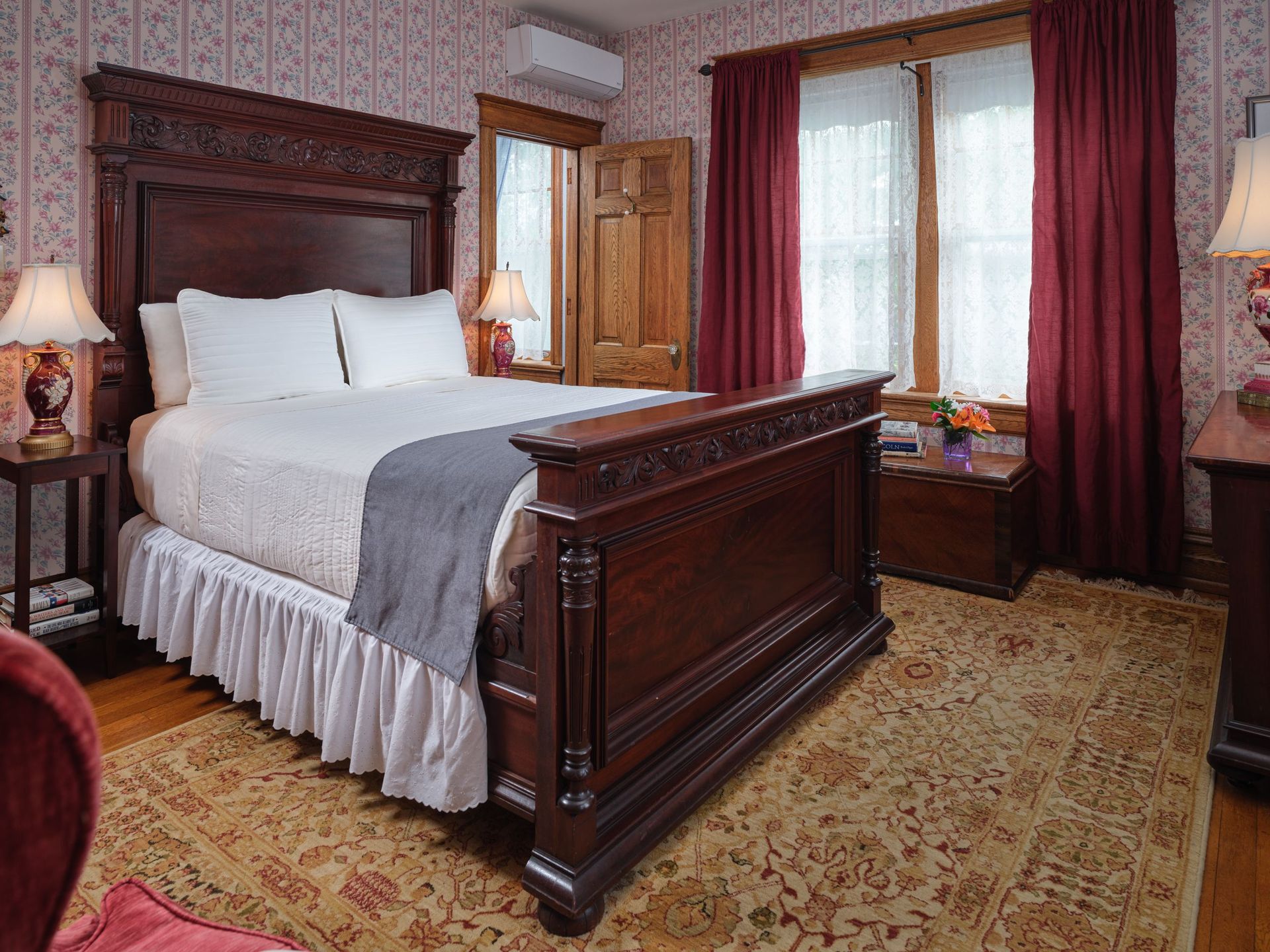 A bedroom with a king size bed and red curtains