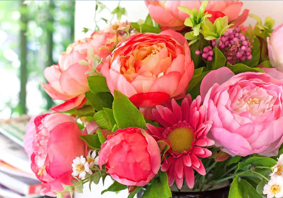 A bouquet of pink flowers in a vase on a table.