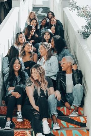 A group of women are sitting on a set of stairs.