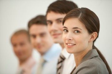 A group of people are standing in a row and smiling at the camera.