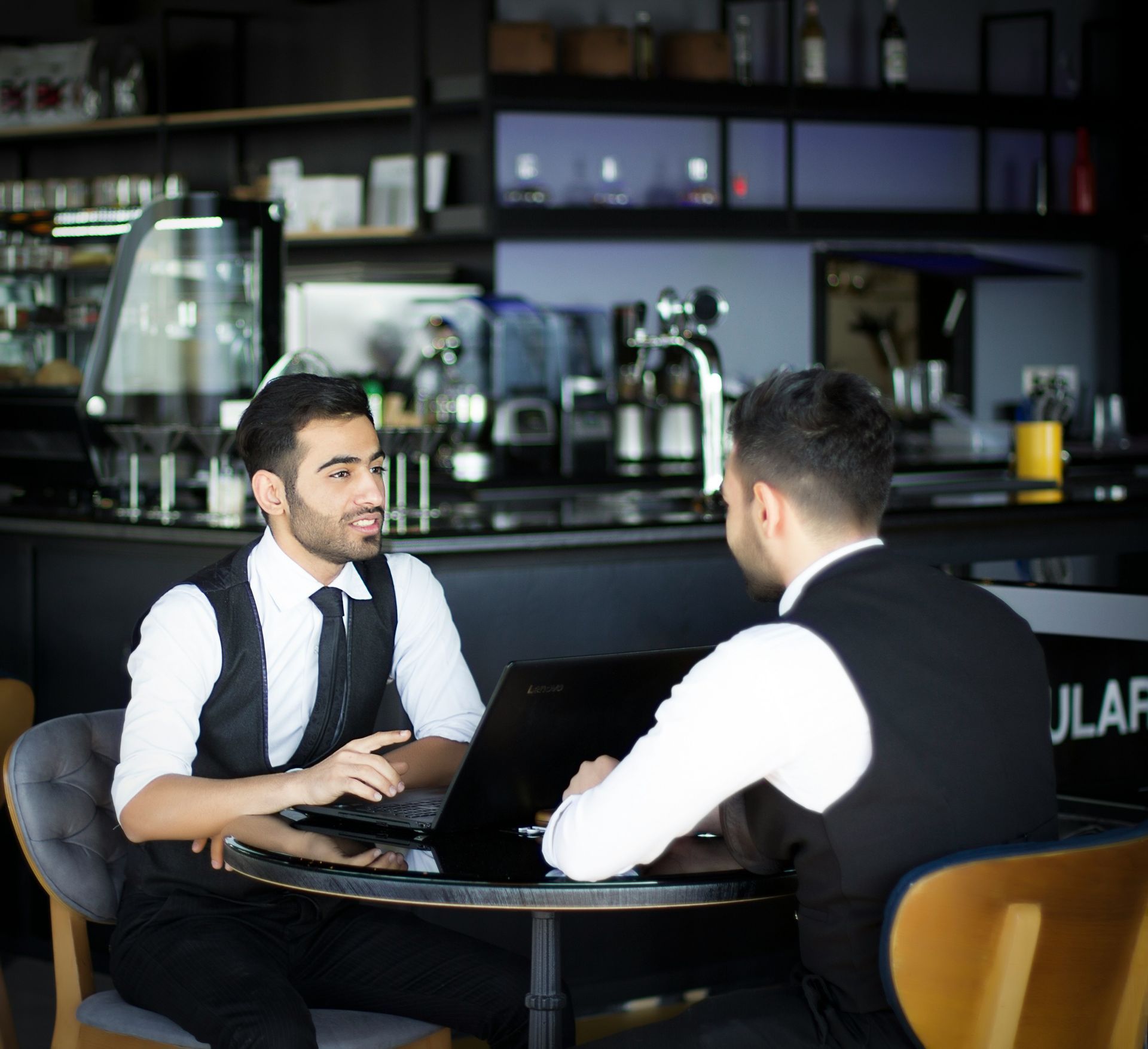 Des desserts dressés sur une chaîne de montage dans la cuisine d'un restaurant. Les serveurs se préparent à servir les plats.