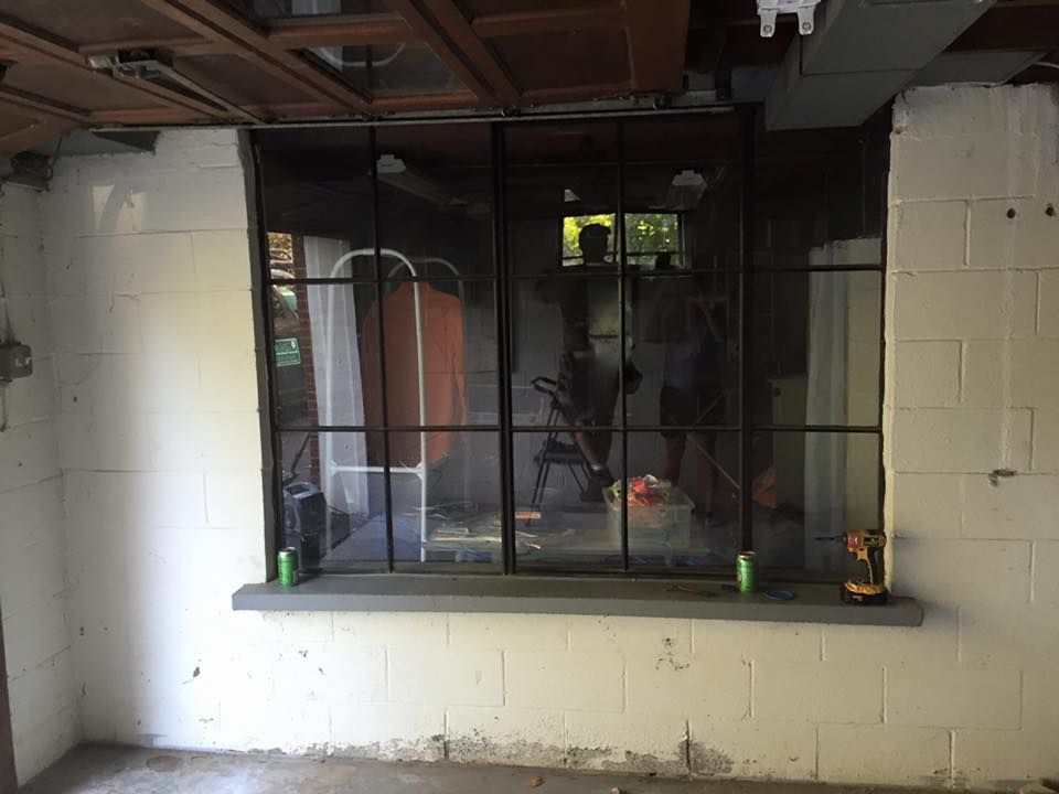 A white brick wall with a window in the middle of it.