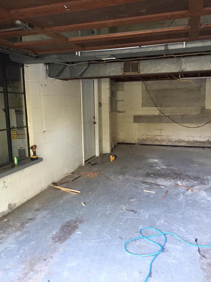 An empty basement with a door and a window.