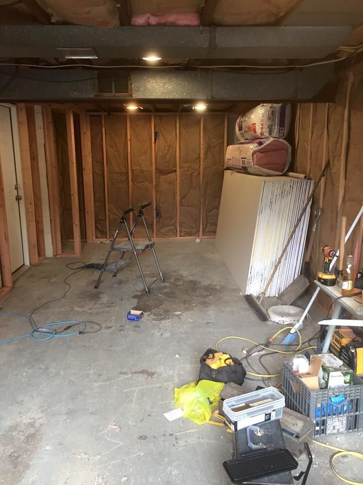 A basement under construction with a lot of tools on the floor.