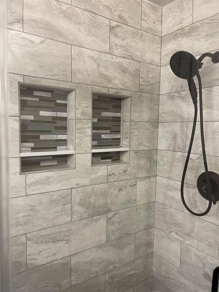 A shower with two niches and a black shower head.