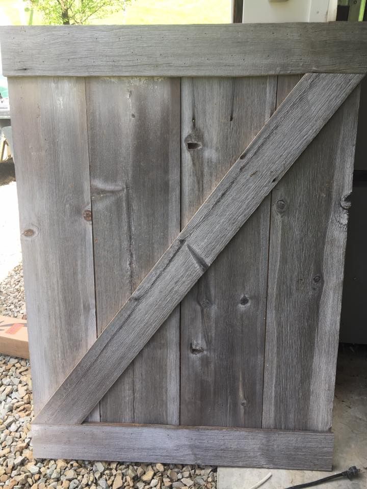 A wooden gate is sitting on top of a pile of gravel.