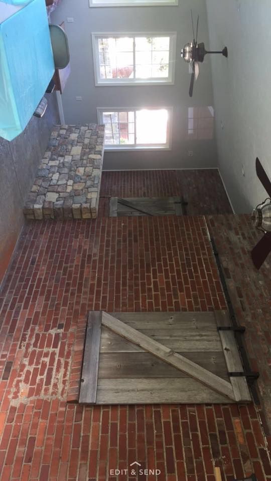A brick wall with a wooden door and a ceiling fan.