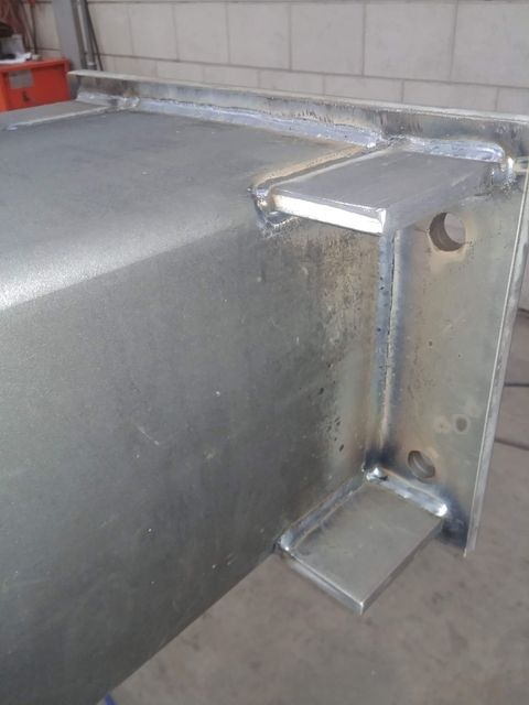 Een close-up van een metalen balk met een gat erin.