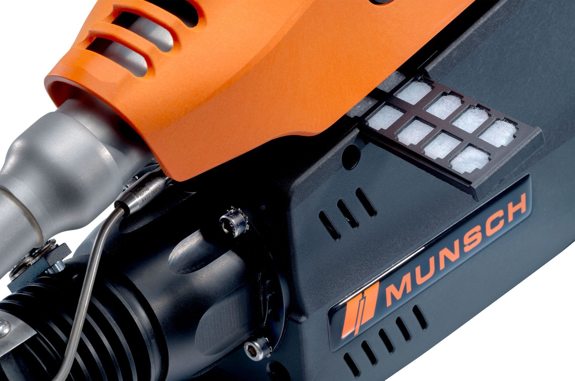 Primer plano de una herramienta eléctrica Munsch de color naranja y negro con carcasa ventilada.