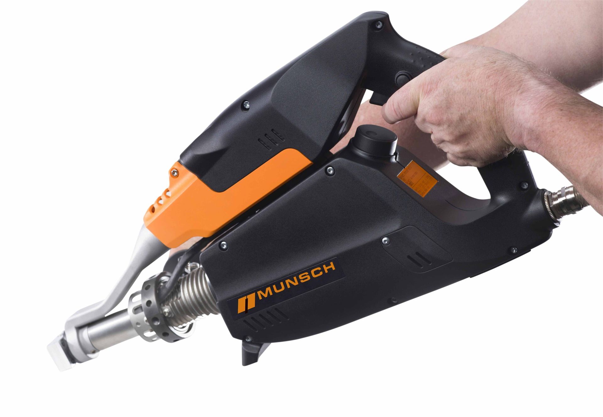 Mano sosteniendo una herramienta eléctrica manual negra y naranja con boquilla metálica.