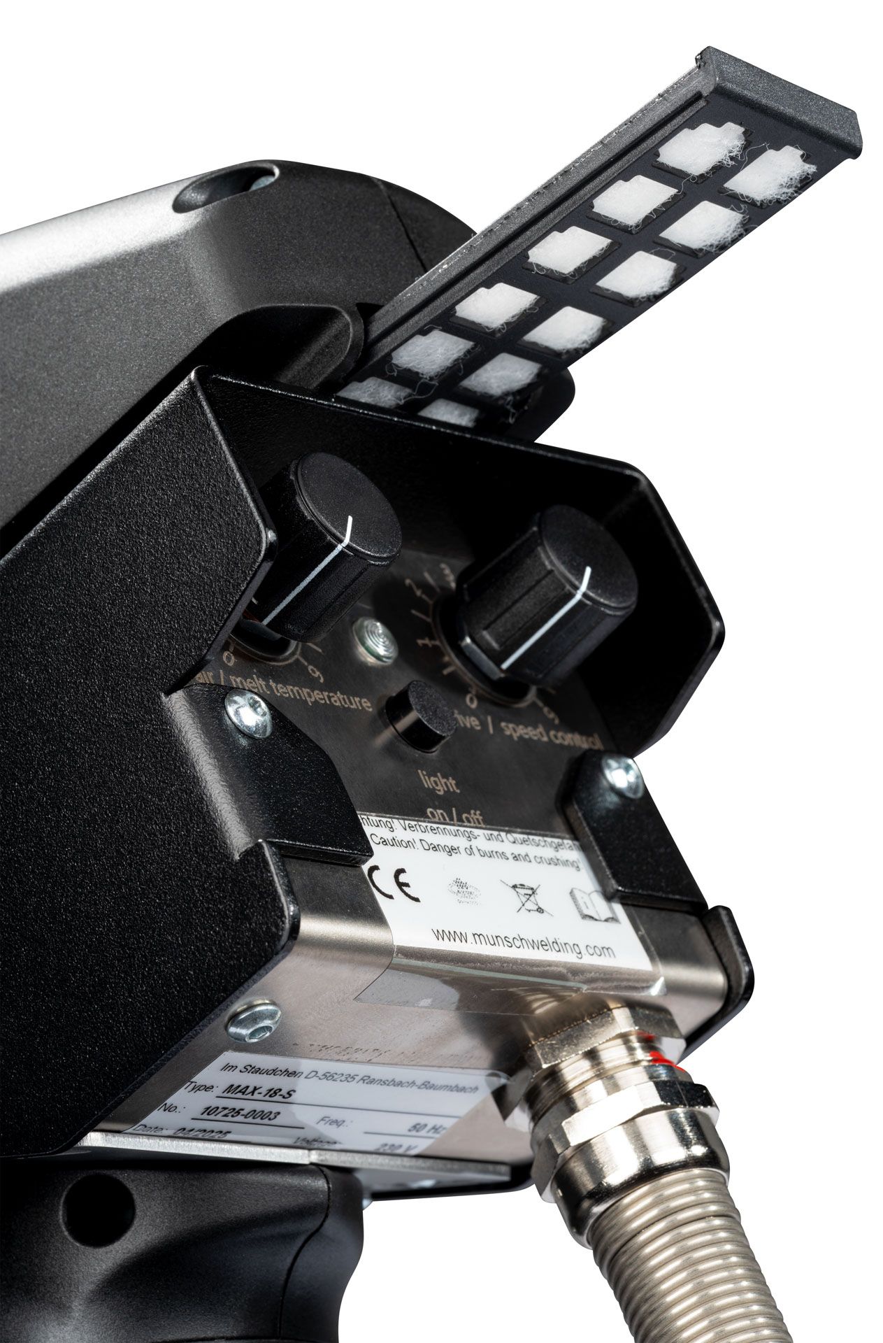 Primer plano de una cámara industrial negra con un cable flexible y un panel de luz LED acoplado.