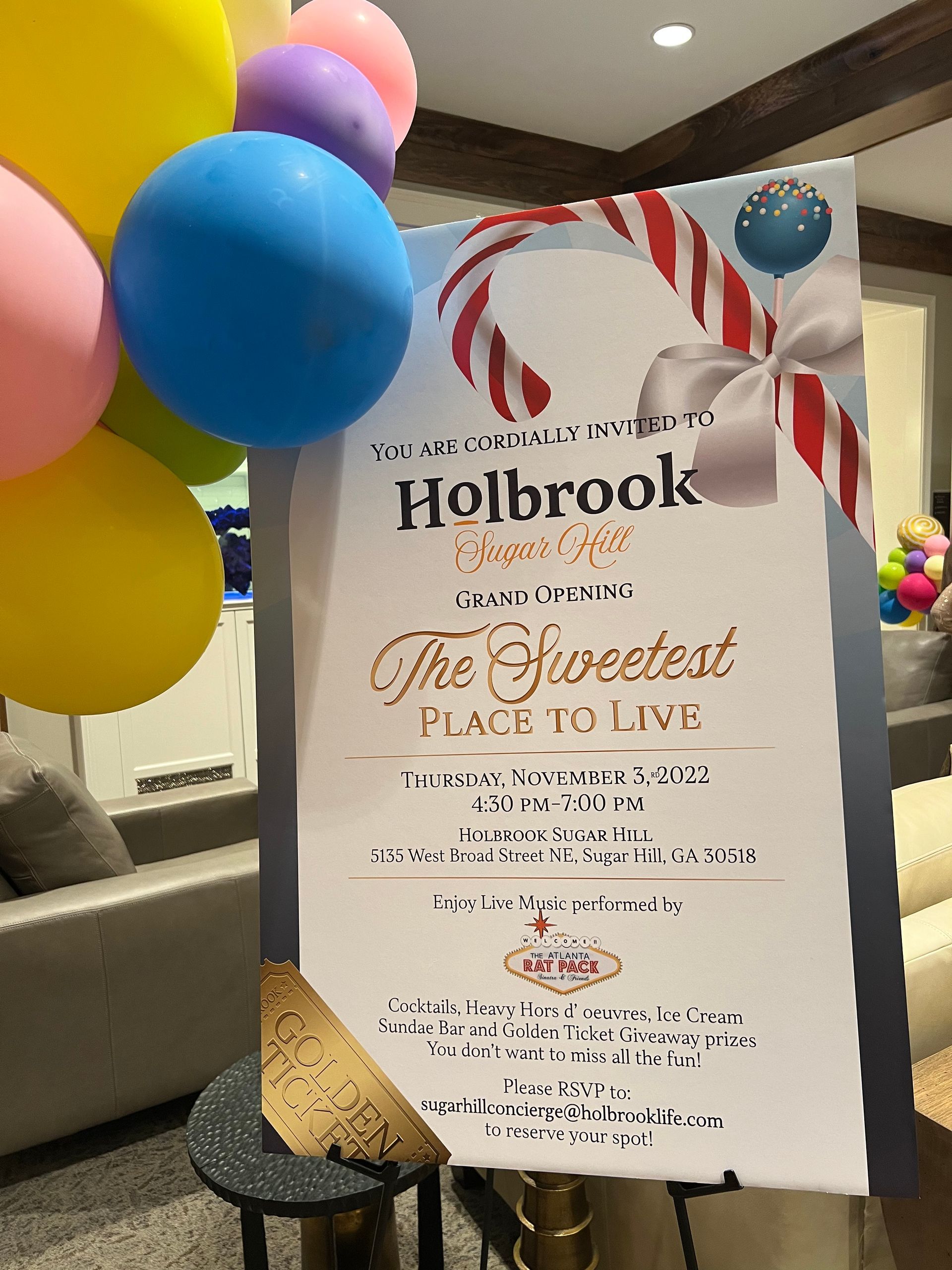 A sign that says `` the sweetest place to live '' is sitting on a table next to balloons.