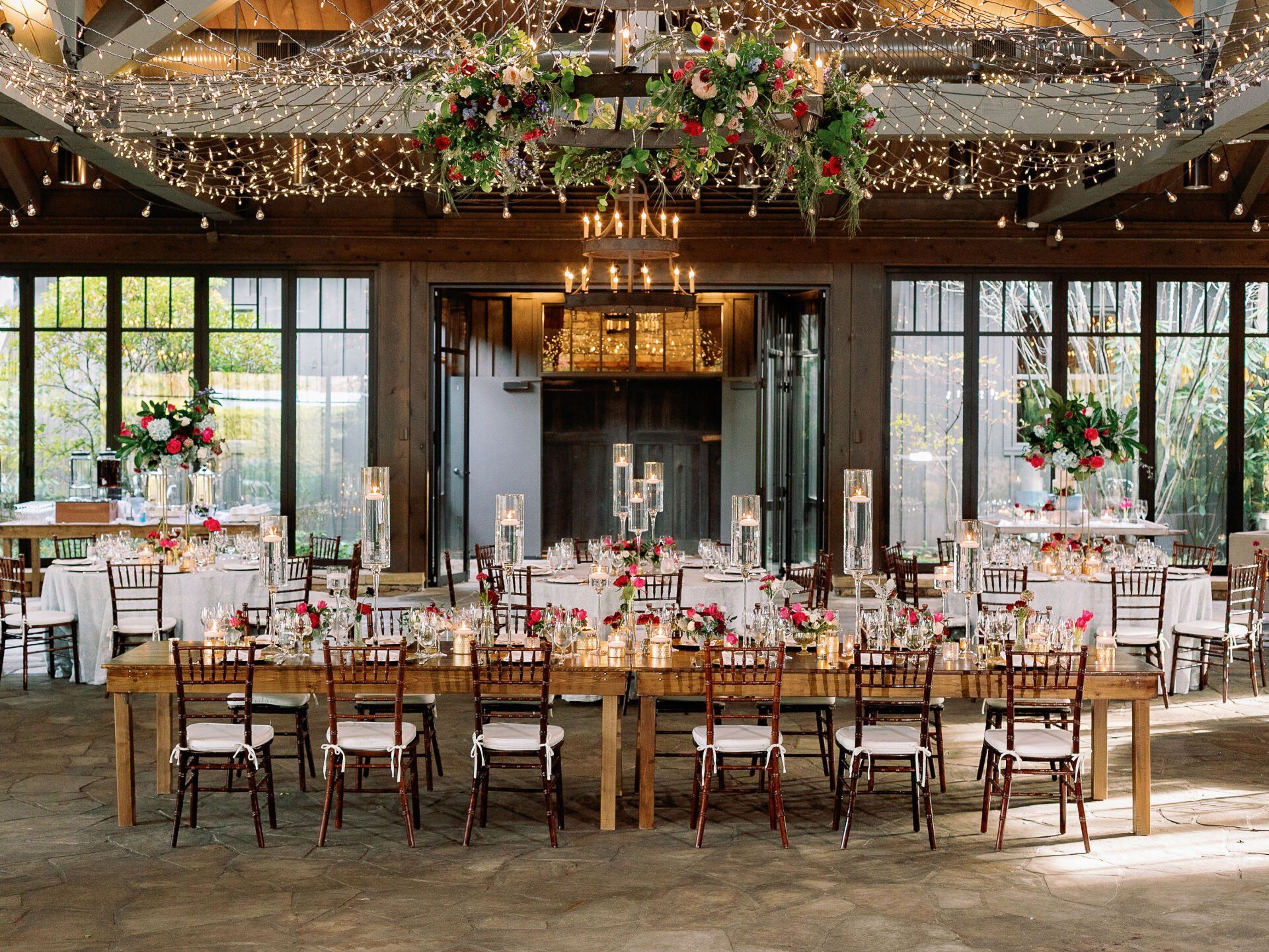 A large room with tables and chairs set up for a wedding reception.