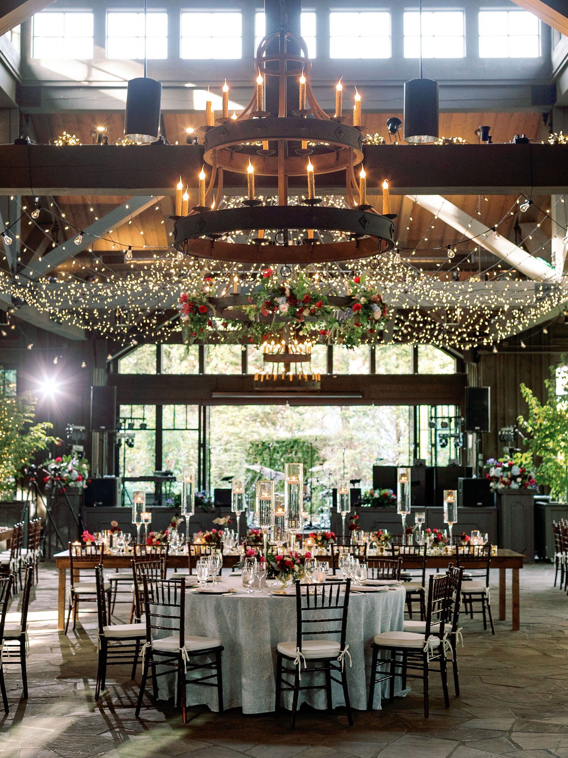 A large room with tables and chairs and a chandelier hanging from the ceiling