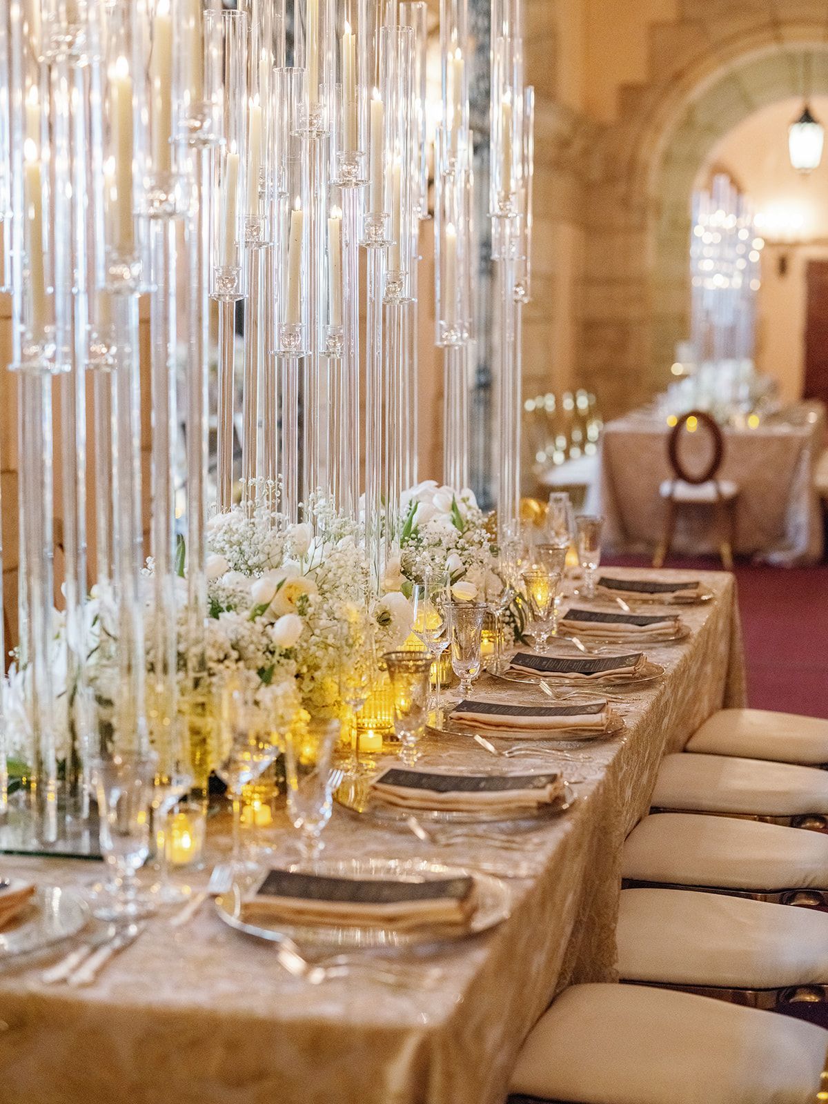 A long table with plates , candles , and flowers on it.