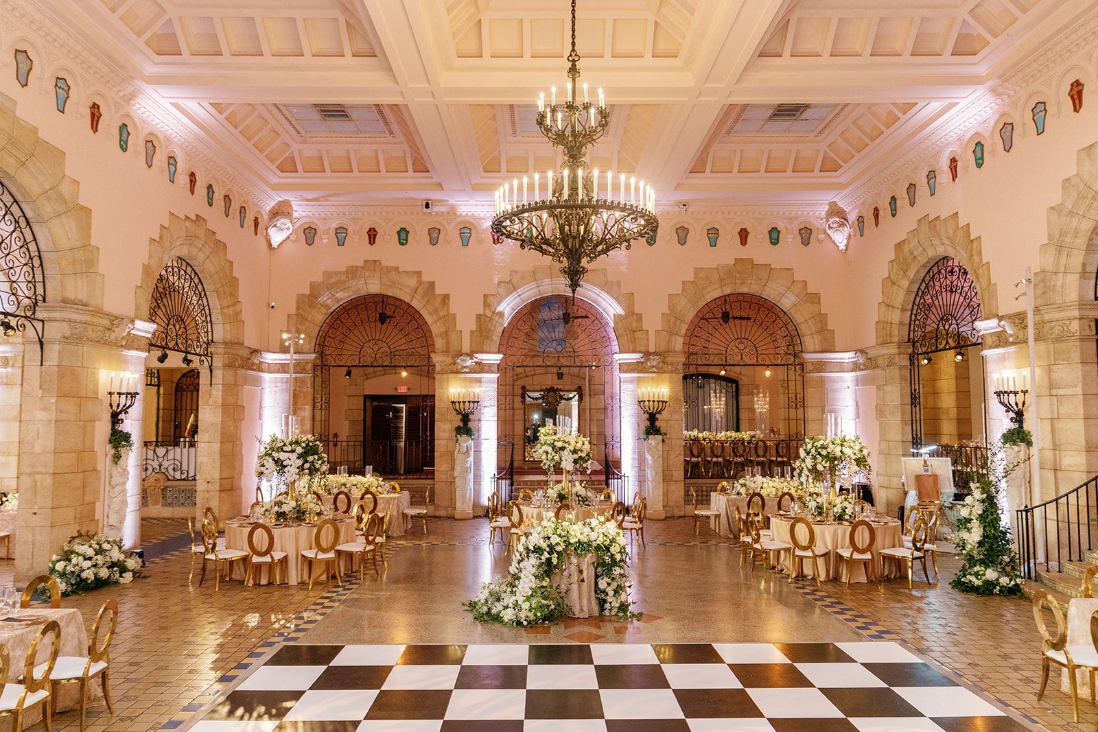 A large room with tables and chairs and a checkered dance floor.