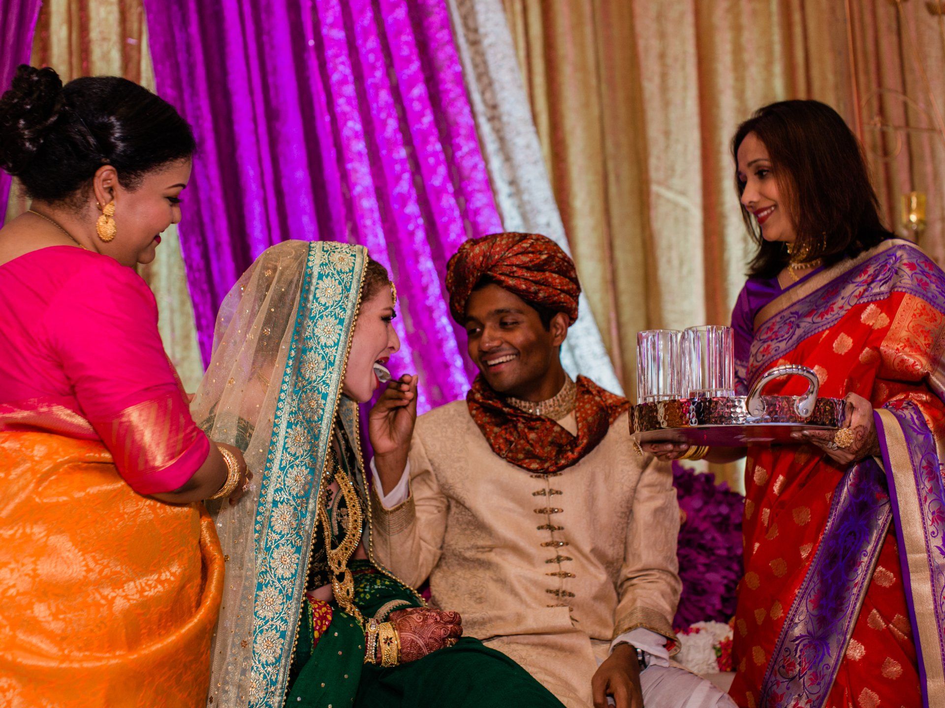 A bride and groom are sitting next to each other at a wedding reception.