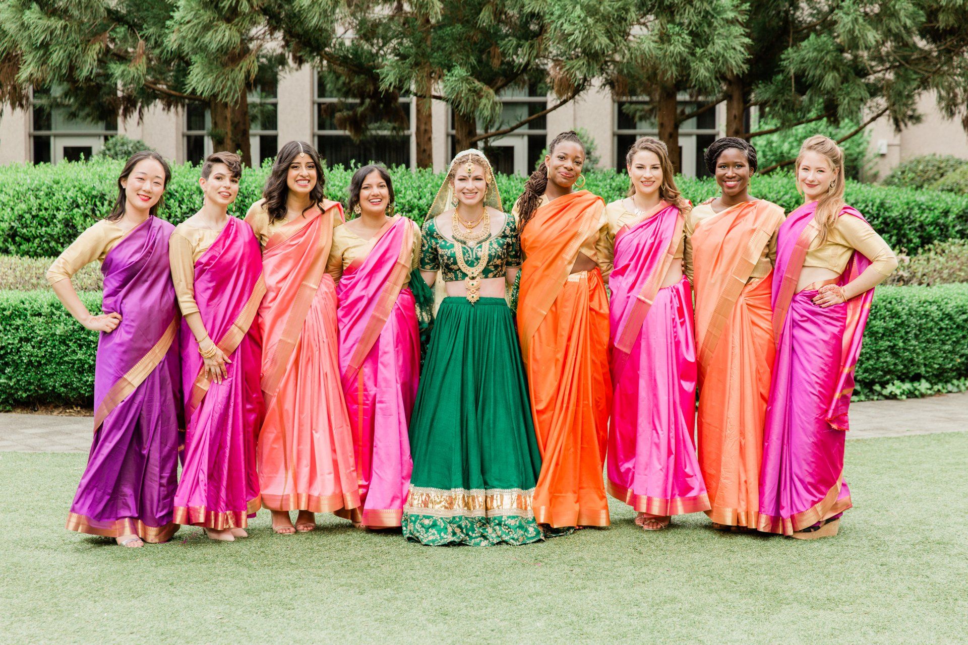 A group of women in saris are posing for a picture.
