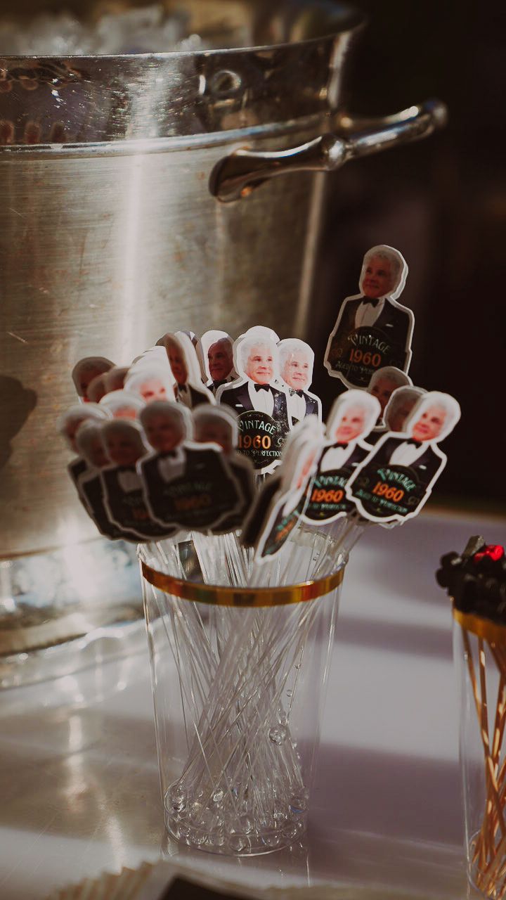 Mini figures in cups with sparkly silver stems on a table beside a metal bucket