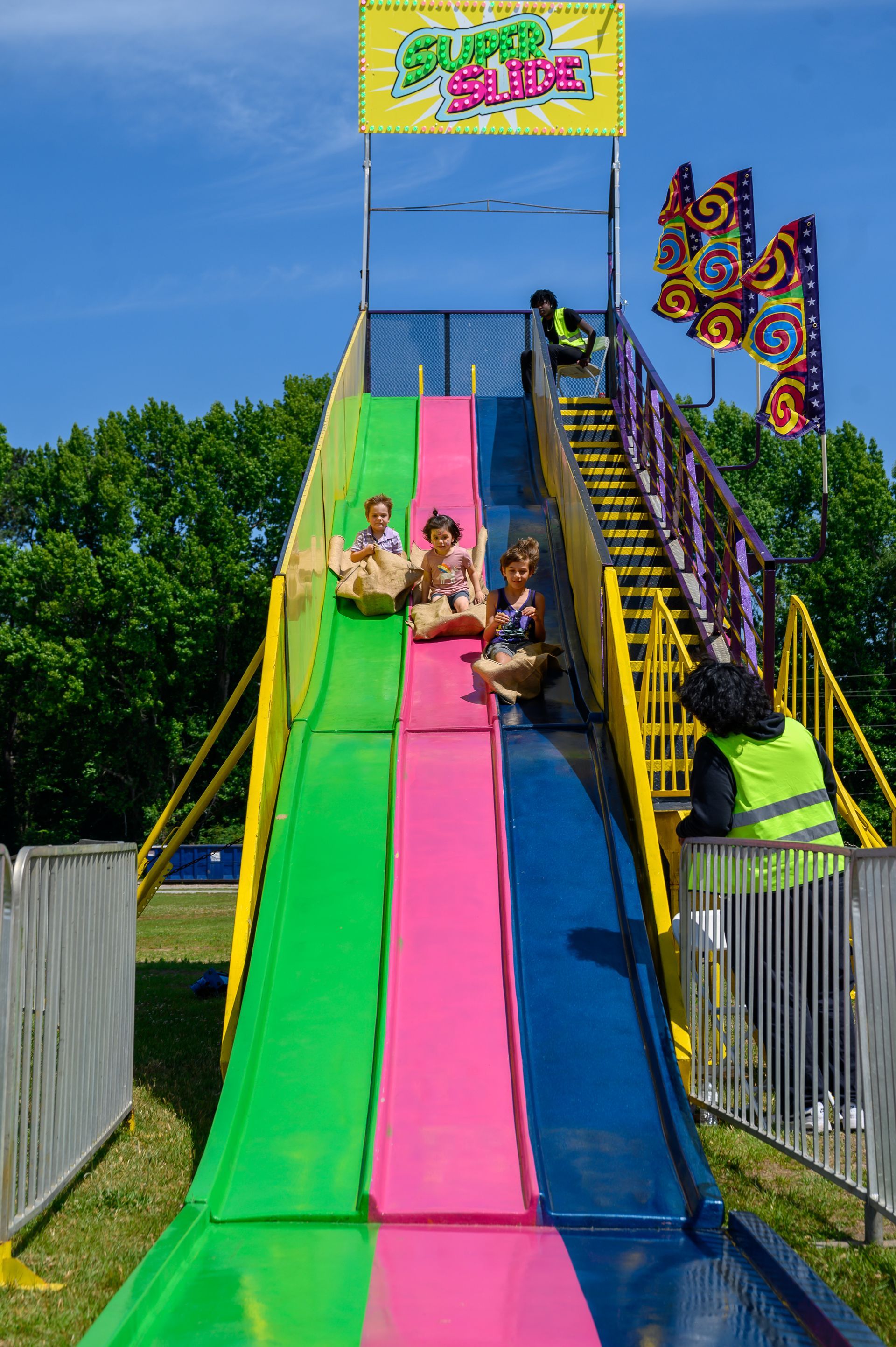 A group of people are riding down a colorful slide.