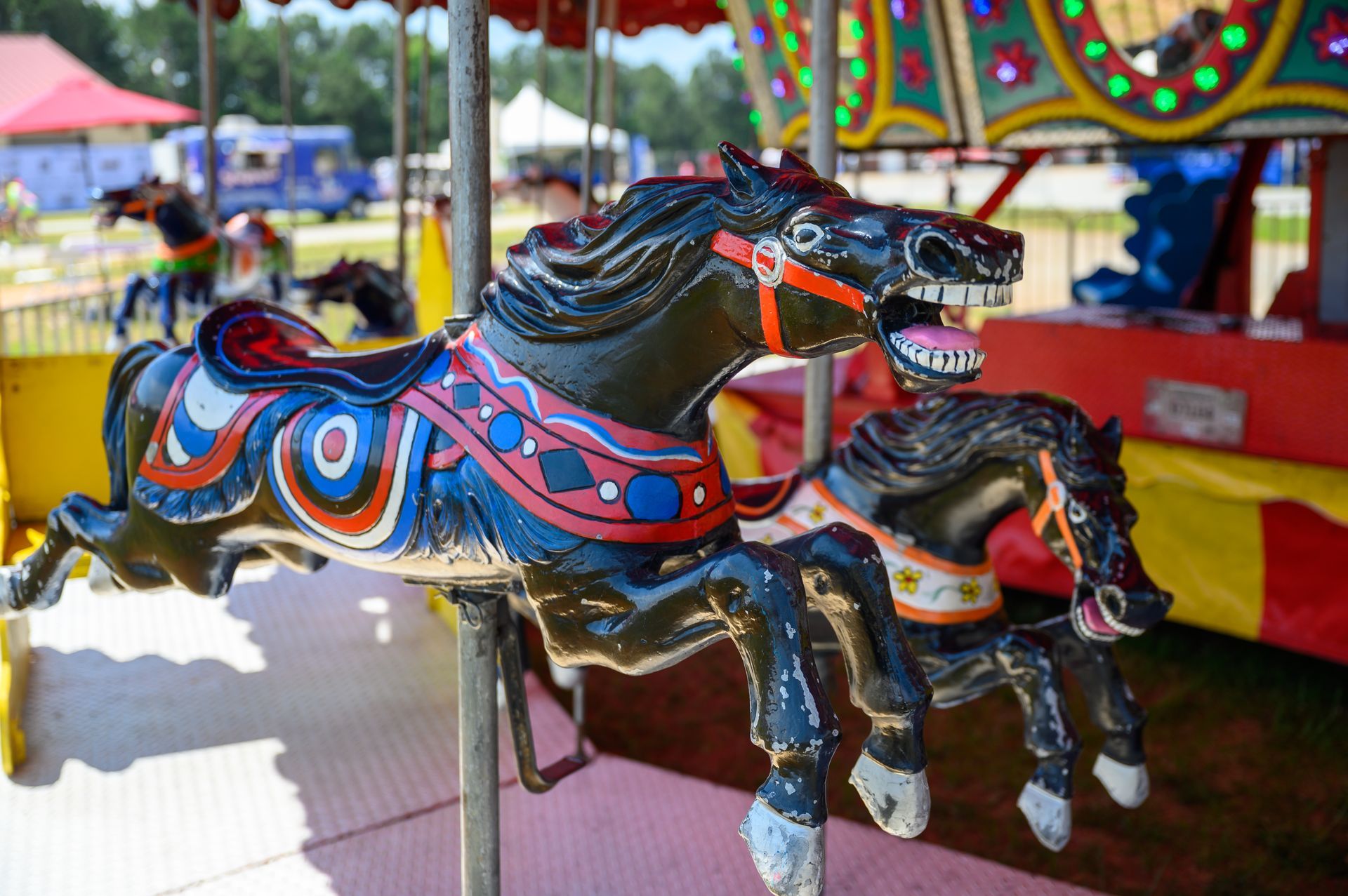 A merry go round with three horses on it.