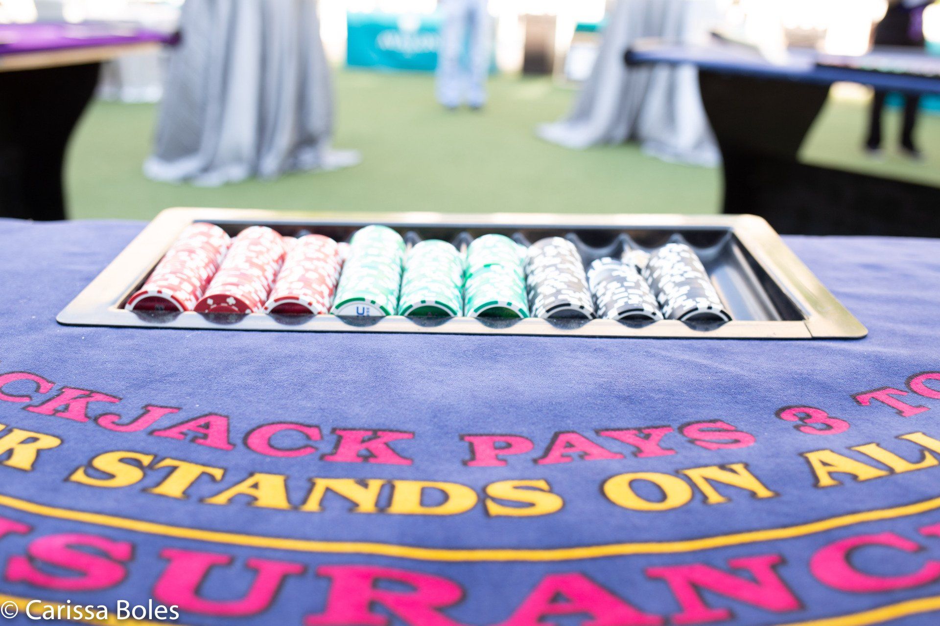 A tray of poker chips sits on top of a blackjack table