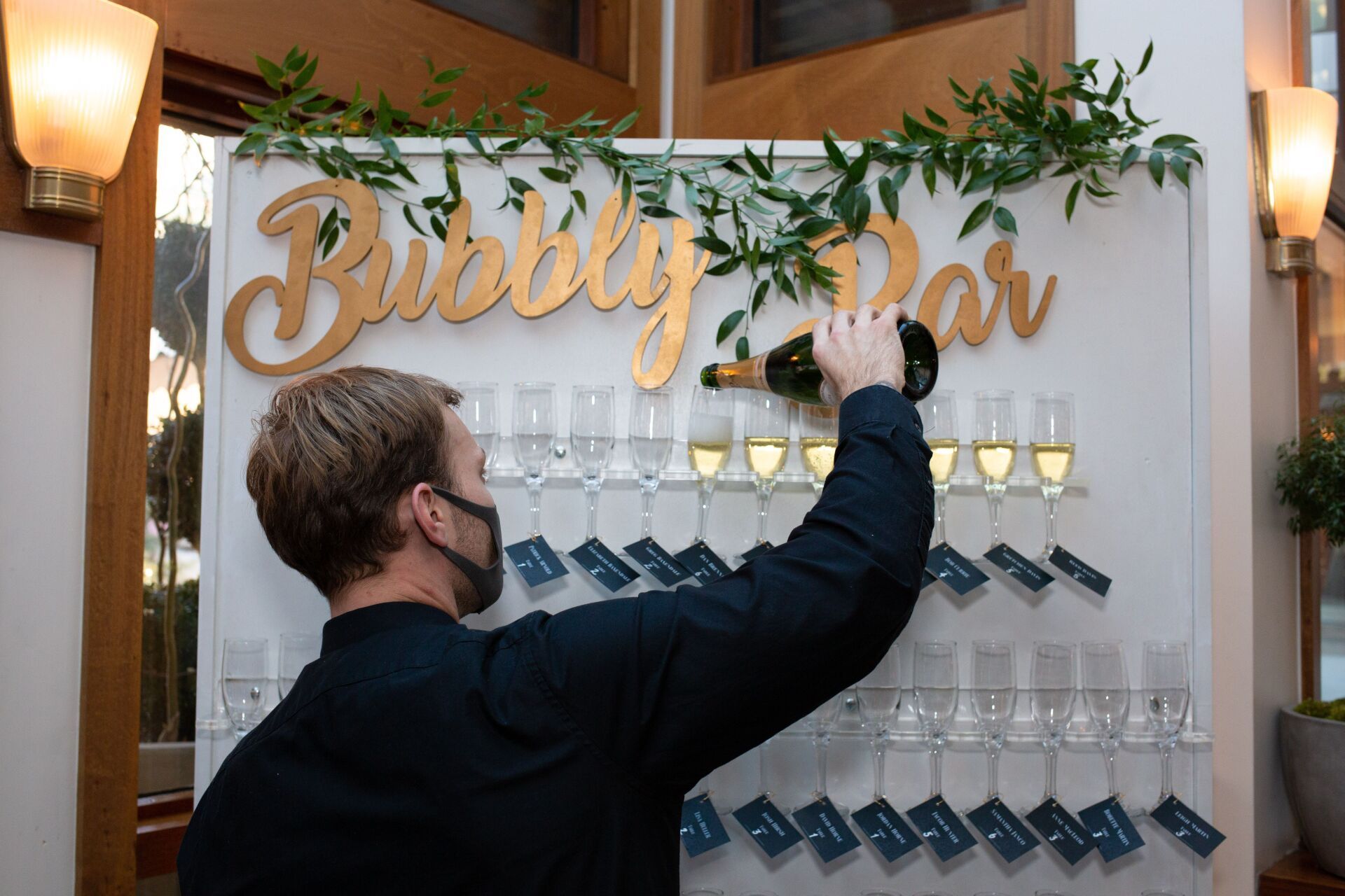 A man is pouring a bottle of champagne into a bubble bar.