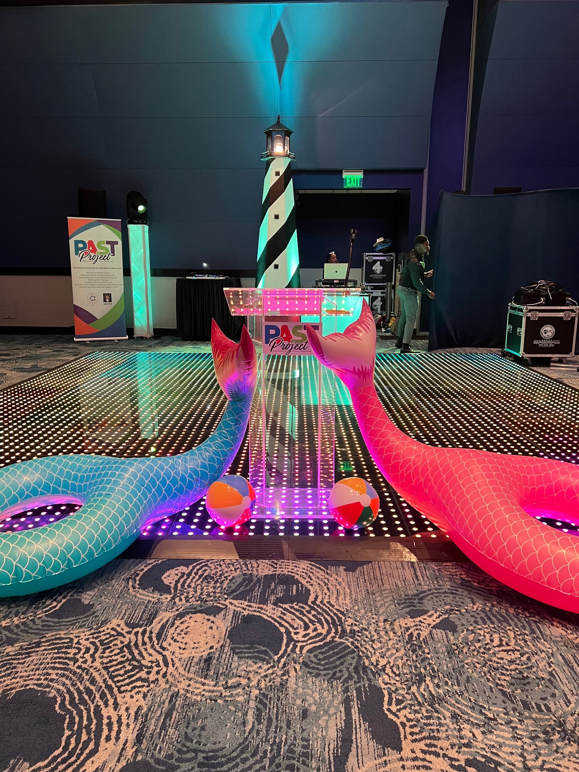 A couple of inflatable flamingos sitting on top of a dance floor.