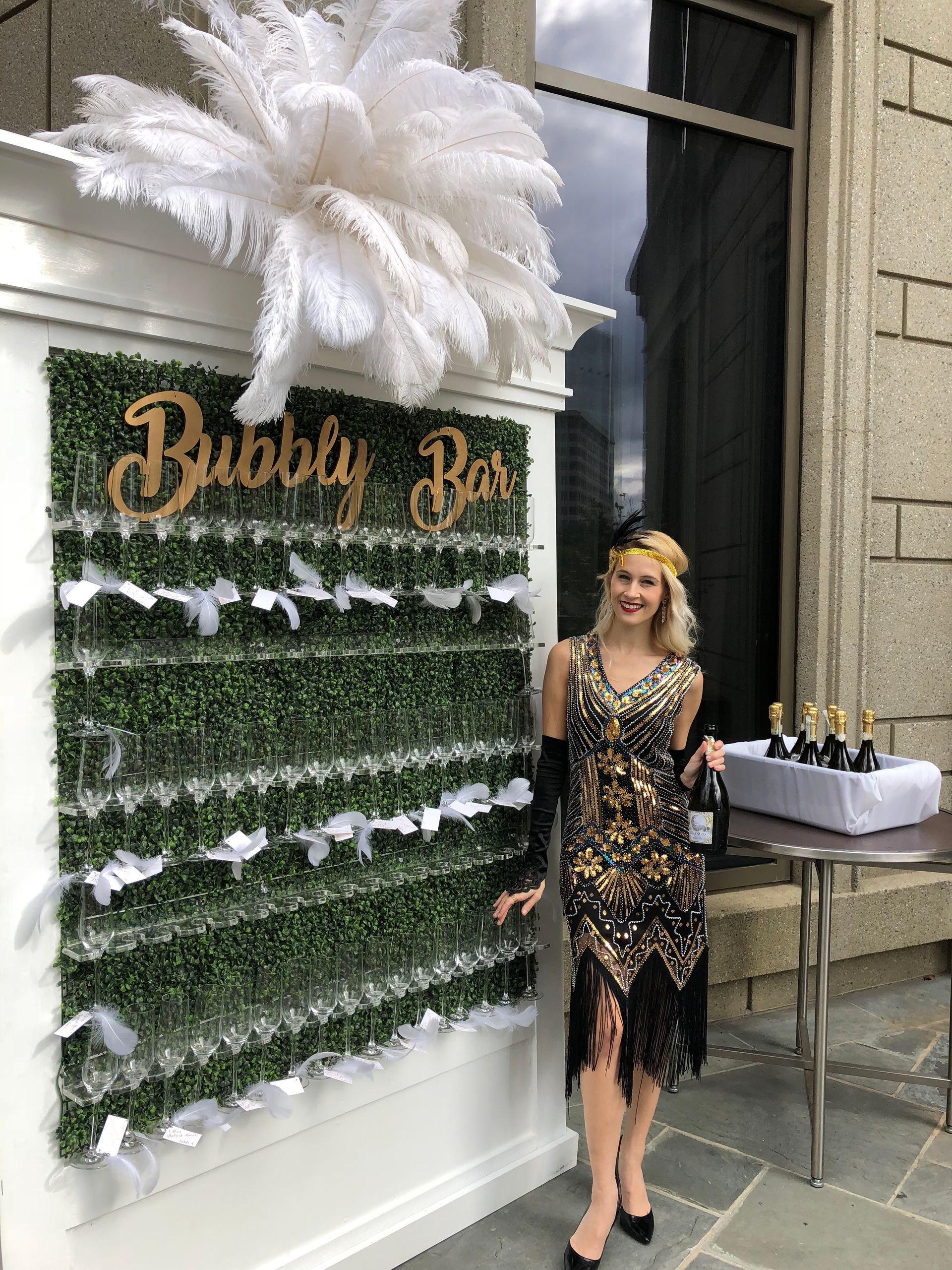 A woman in a flapper dress is standing in front of a bubble wall.