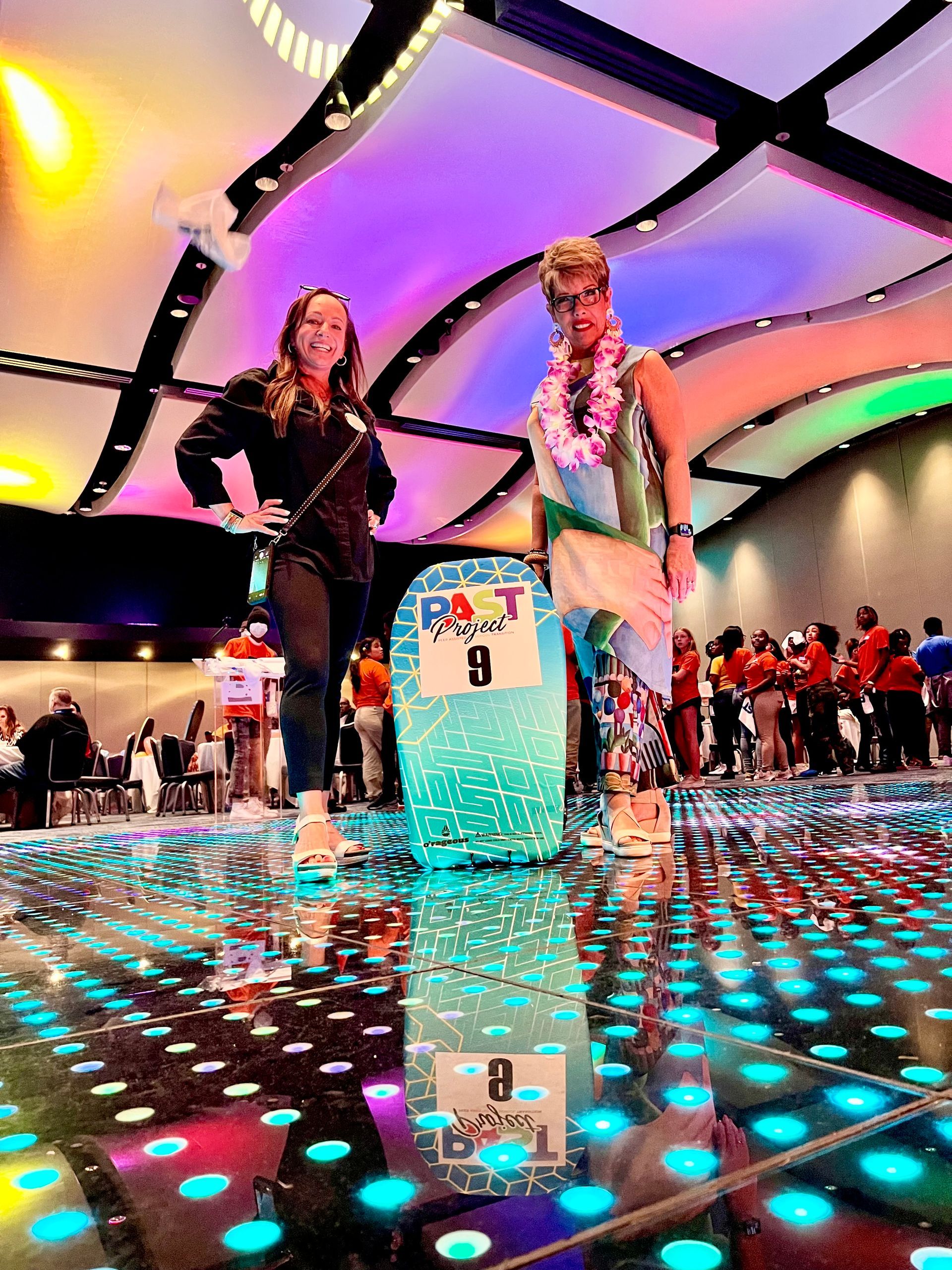 A couple of people standing next to each other on a dance floor.