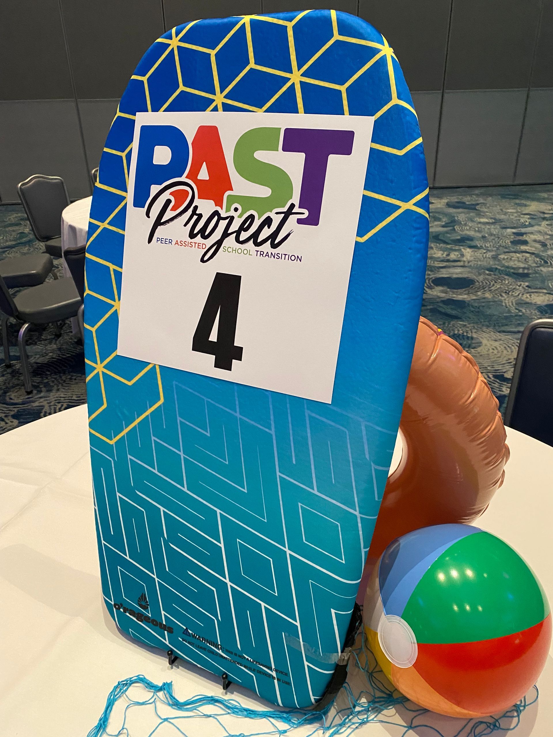 A table with a surfboard and a beach ball on it.