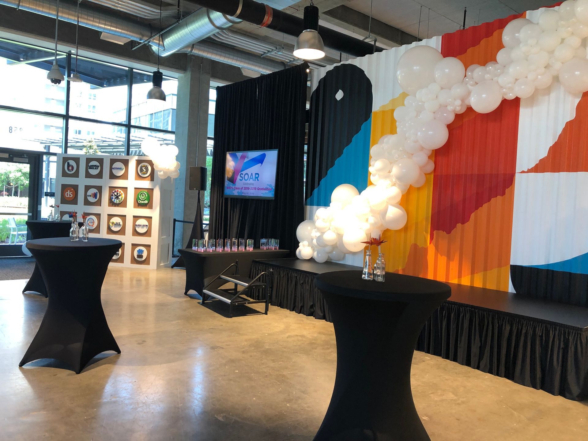a room with tables and balloons on the wall .