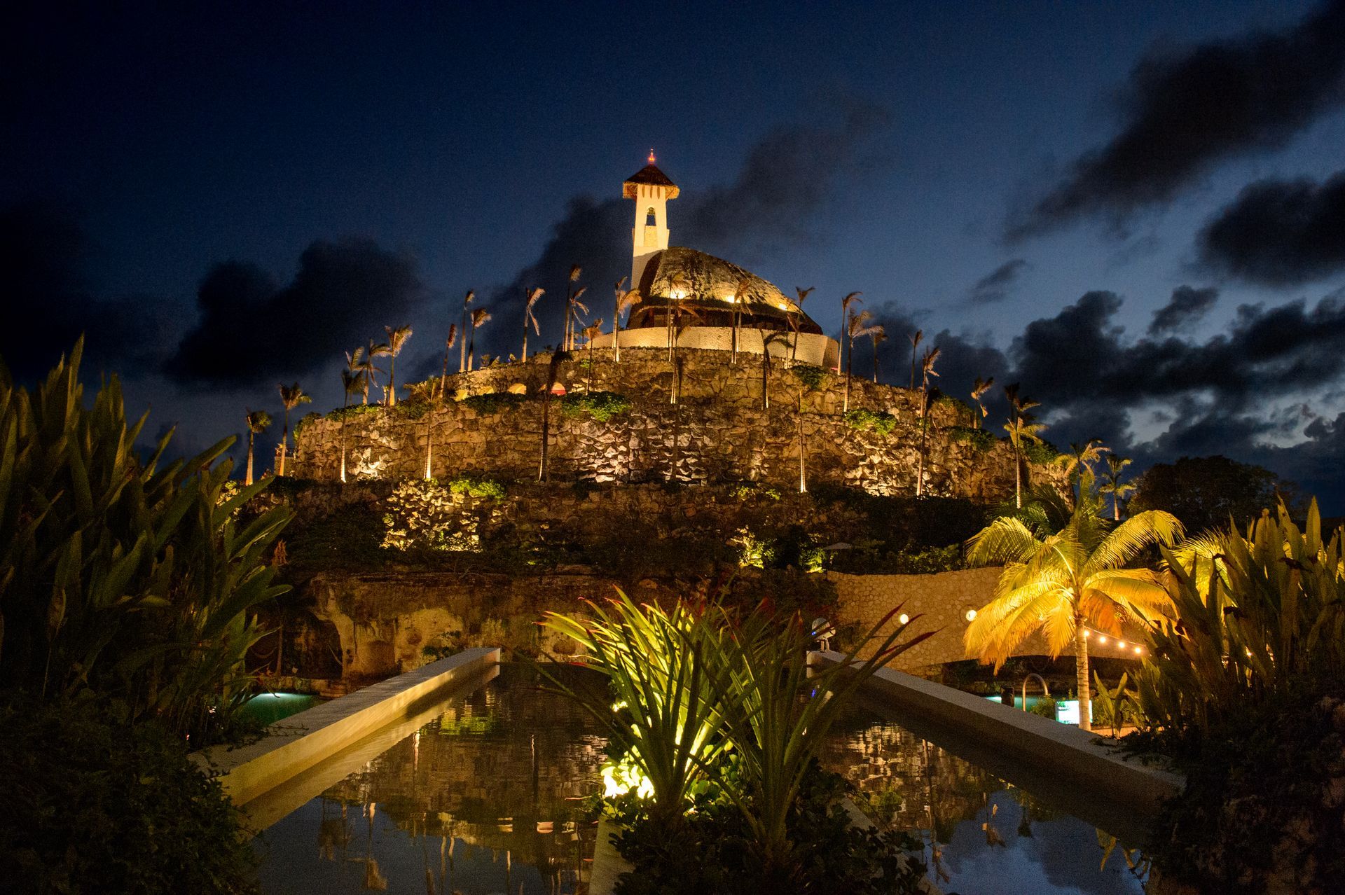 A lighthouse on top of a hill at night