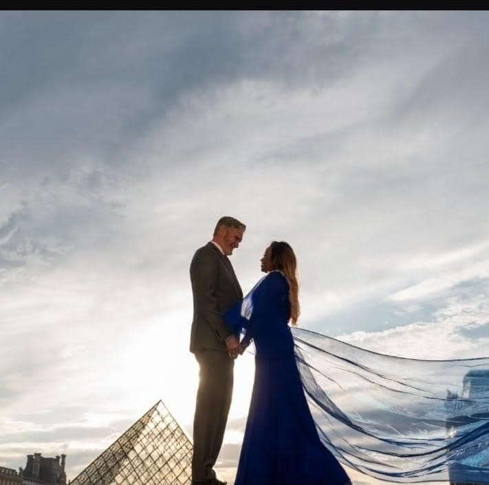 A man in a suit and a woman in a blue dress are standing next to each other