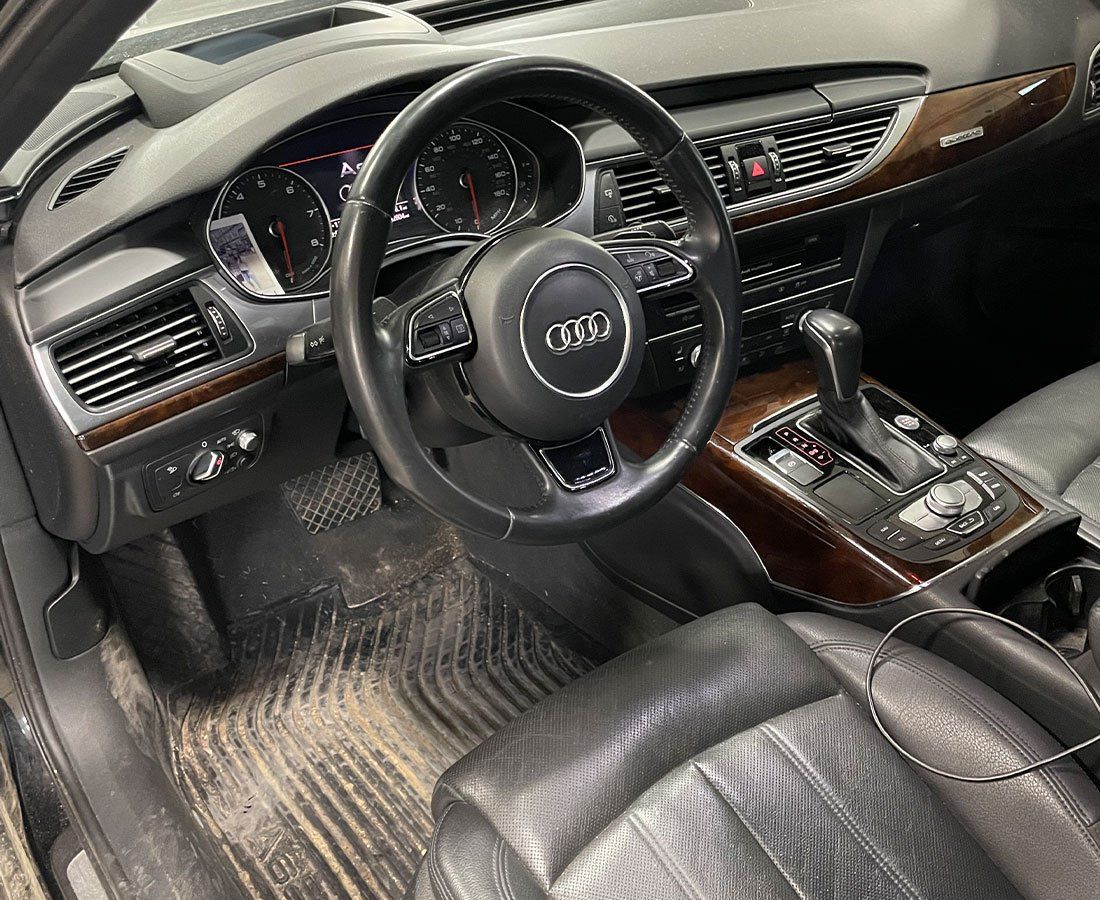 The interior of a car with a steering wheel and a dashboard.