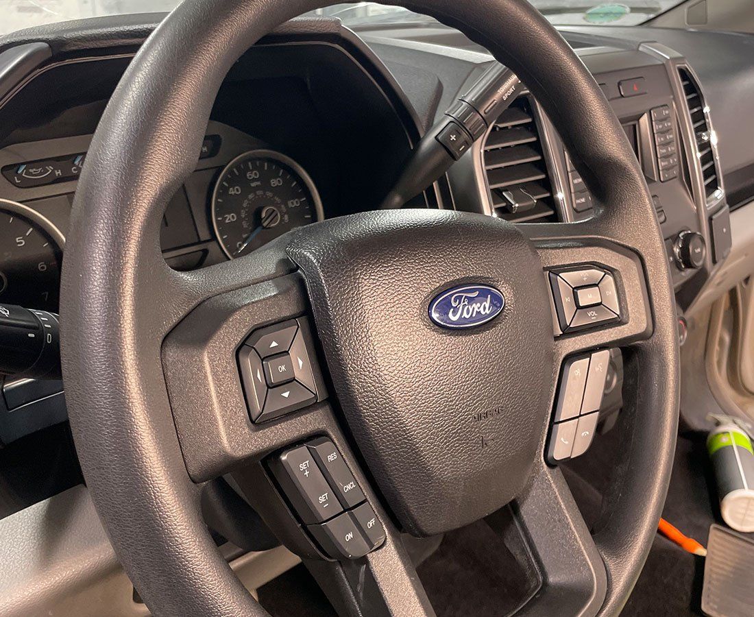 A close up of a ford steering wheel in a car