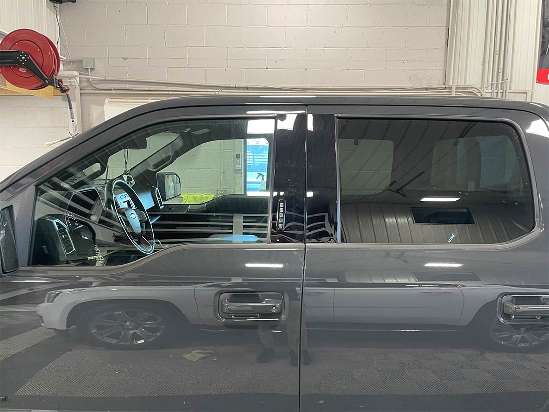 A gray pickup truck is parked in a garage.