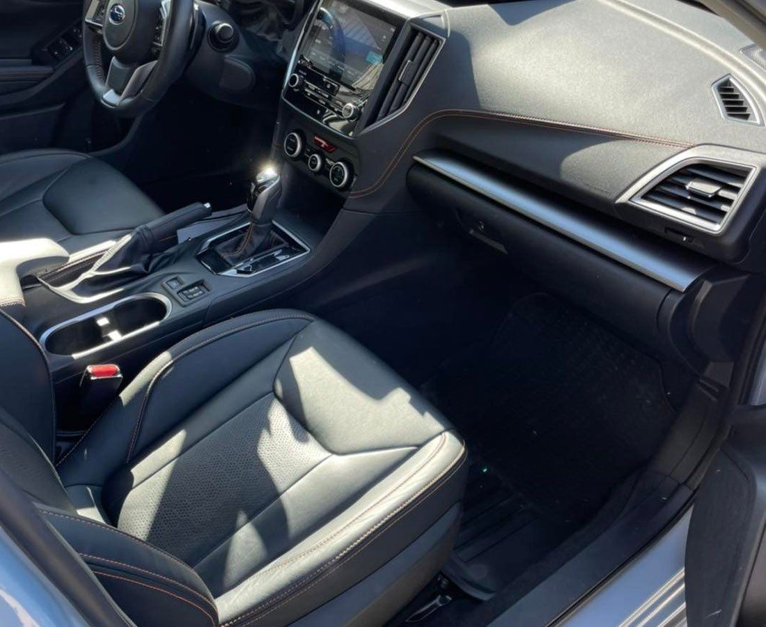 The interior of a silver car with black seats