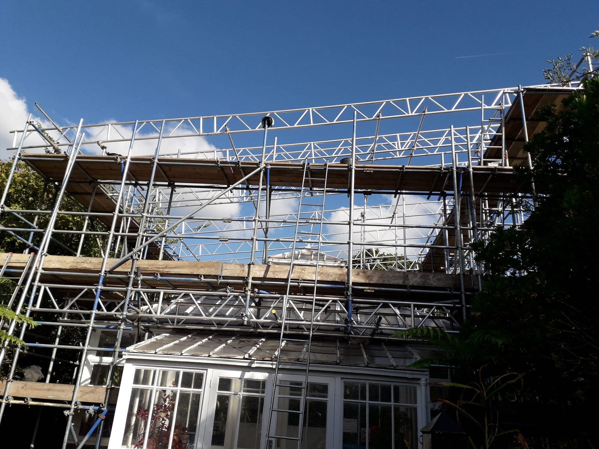 A house is being built with scaffolding on top of it.