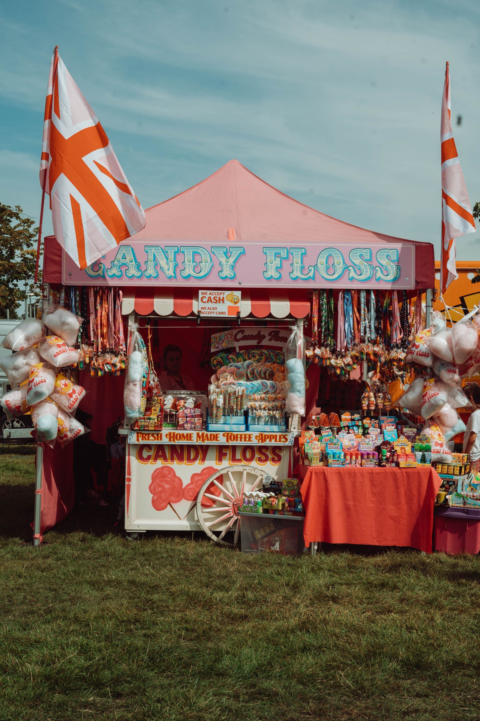 A candy floss stand is sitting in the middle of a field.