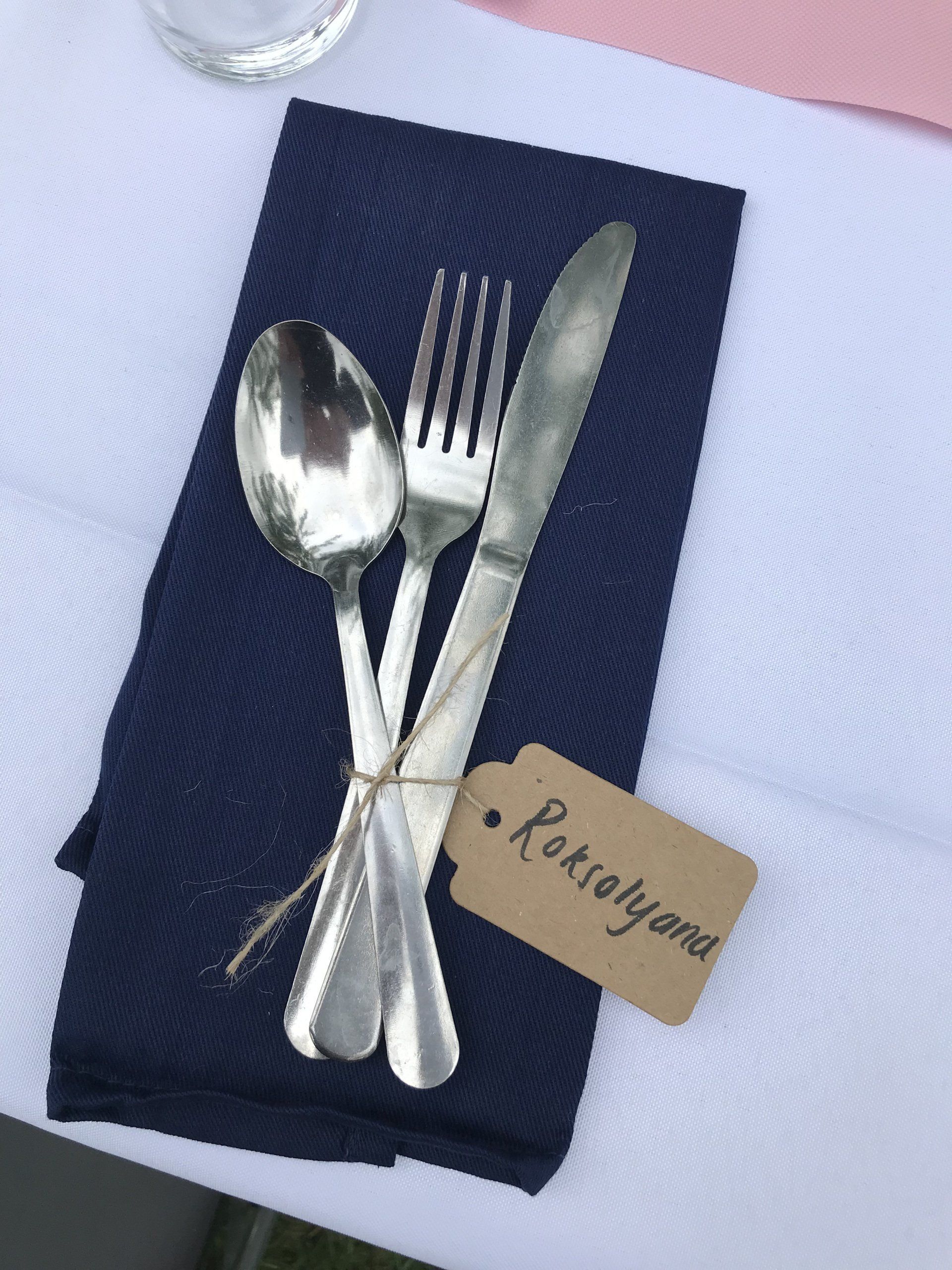 Silverware on a napkin with a name tag that says roselyand