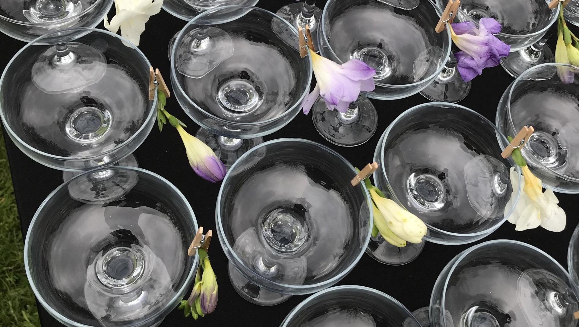 A bunch of champagne glasses filled with ice and flowers on a table.