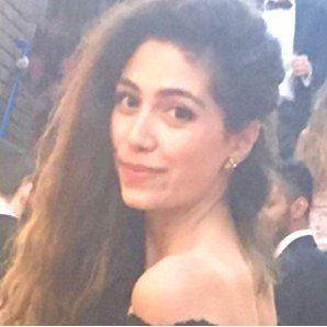 A woman with long hair is wearing earrings and a black dress