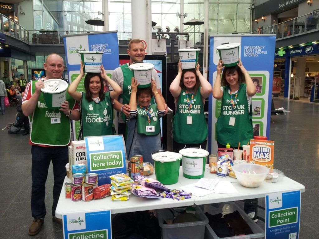 A group of people standing around a table holding buckets over their heads
